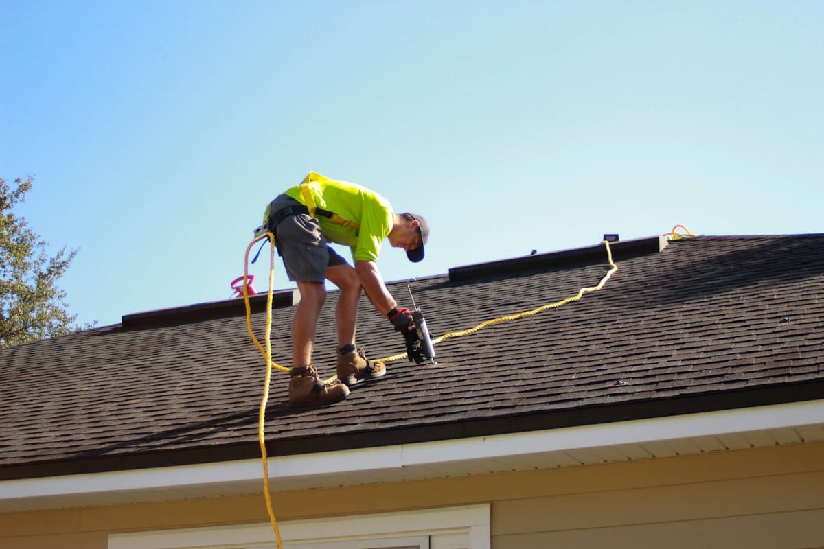 Roofer performing an inspection on a residential shingle roof