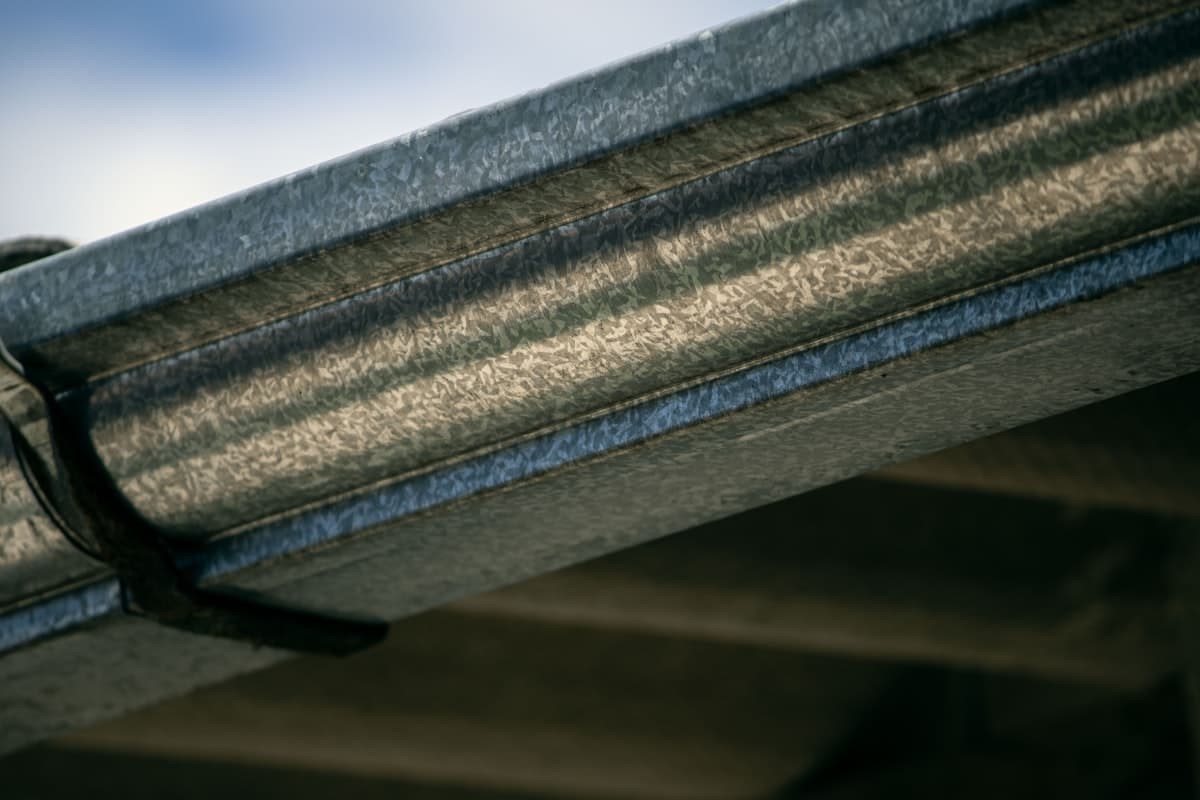 Close-up view of a metal rain gutter attached to a roofline