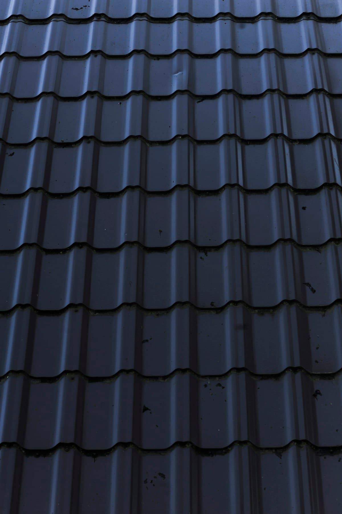 Close-up of a standing-seam metal roof against a blue sky